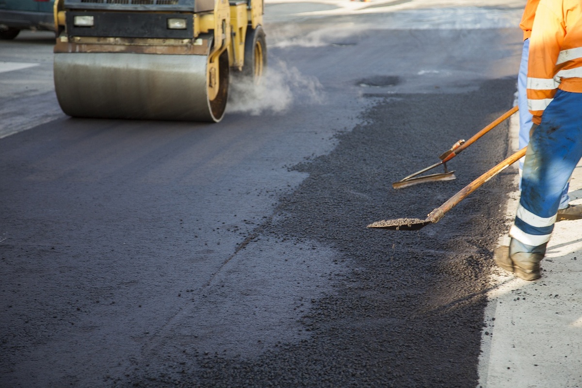 Workers flatting asphalt with shovels