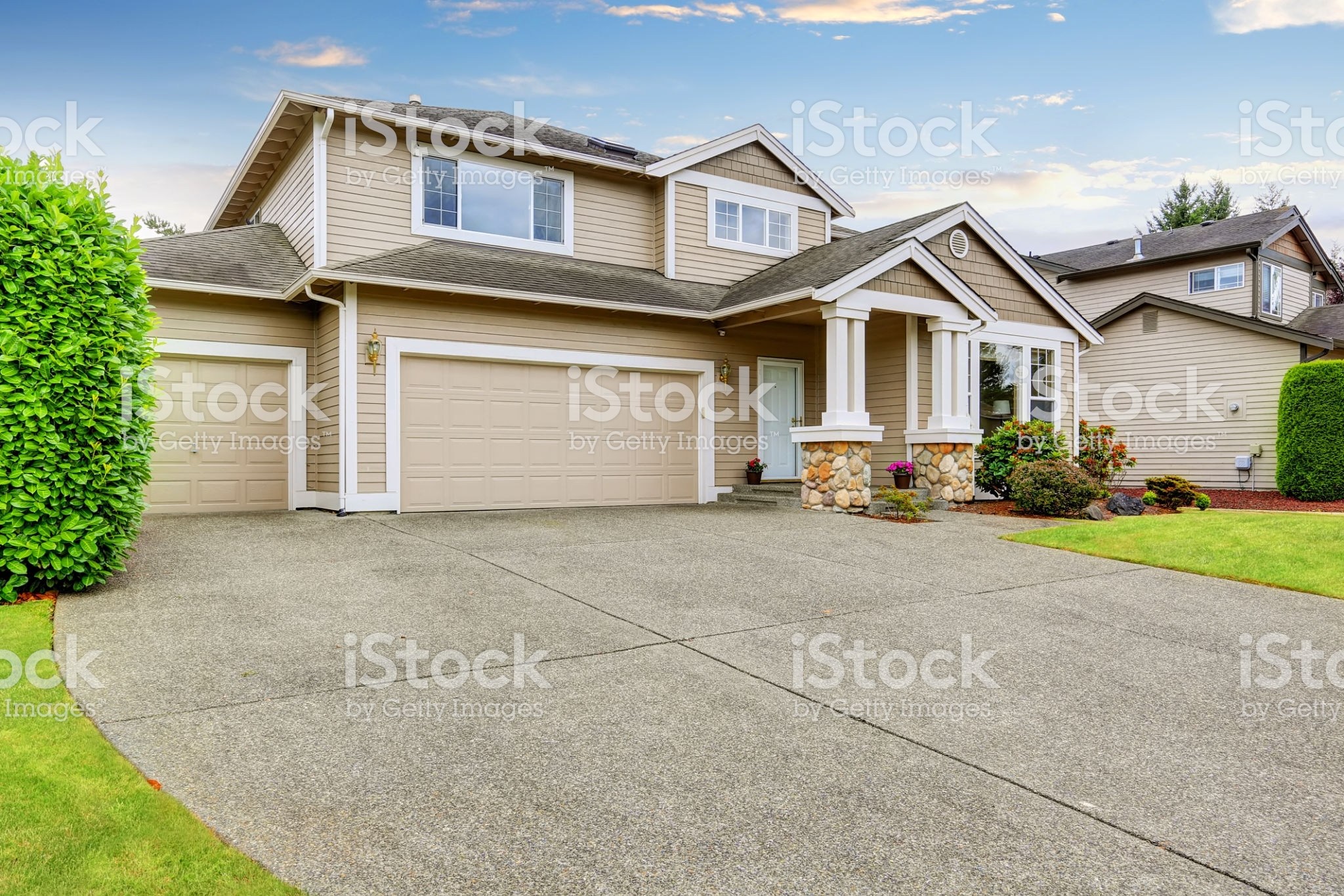 Neat beige home with two garage spaces and large concrete driveway. Northwest, USA